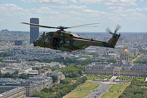 Hélicoptère NH90 en vol devant les Invalides, avec la Tour Montparnasse au fond