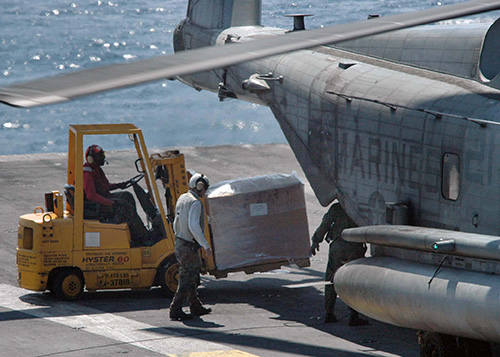 Chargement d'aide humanitaire dans un hélicoptère CH53E SuperStallion