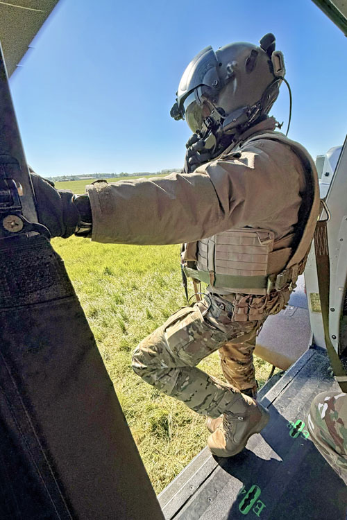 Membre opérationnel de soute (MOS) à la porte d’un NH90 Caïman au moment du décollage