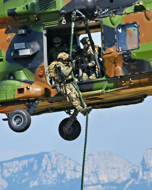 Un à un, les commandos glissent le long de la corde lisse pour rejoindre le sol