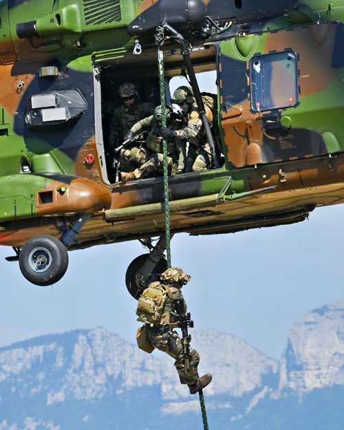 Un à un, les commandos glissent le long de la corde lisse pour rejoindre le sol