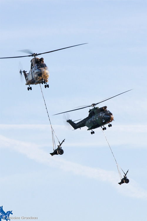 Deux hélicoptères Puma de l'Armée de Terre (ALAT) transportent des pièces d'artillerie sous élingue