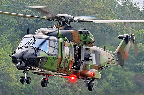 Insertion de commandos sous une pluie battante par un hélicoptère NH90 Caïman de l'Armée de Terre, le door gunner assure la protection de l'appareil en cas de tirs ennemis