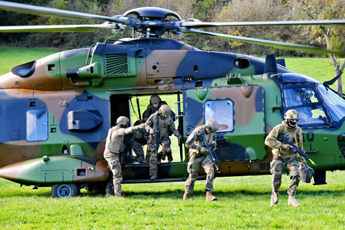 Les militaires débarquent rapidement de l'hélicoptère et se dirigent vers le centre du village