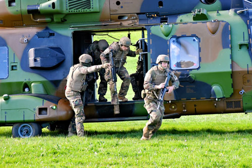 Les militaires débarquent rapidement de l'hélicoptère et se dirigent vers le centre du village