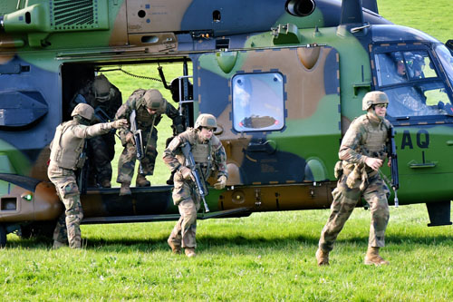 Les militaires débarquent rapidement de l'hélicoptère et se dirigent vers le centre du village